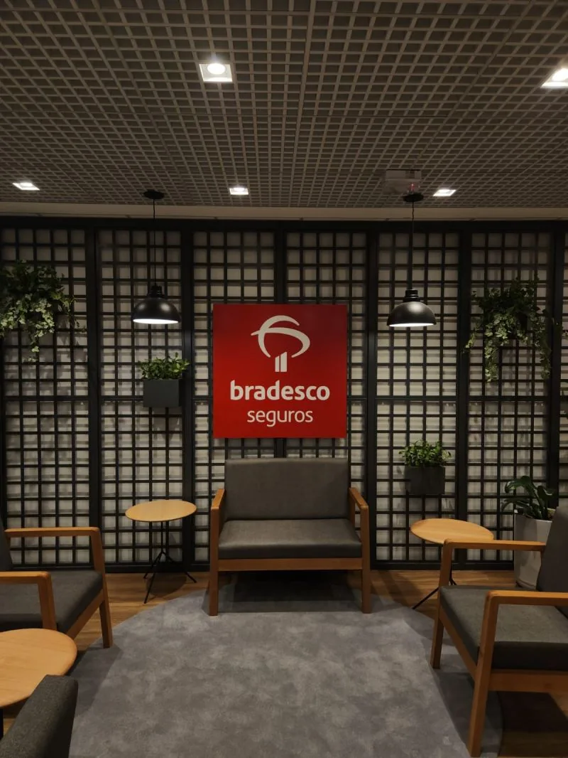 A lounge inside the Bradesco Seguros office, with the company sign on the wall.