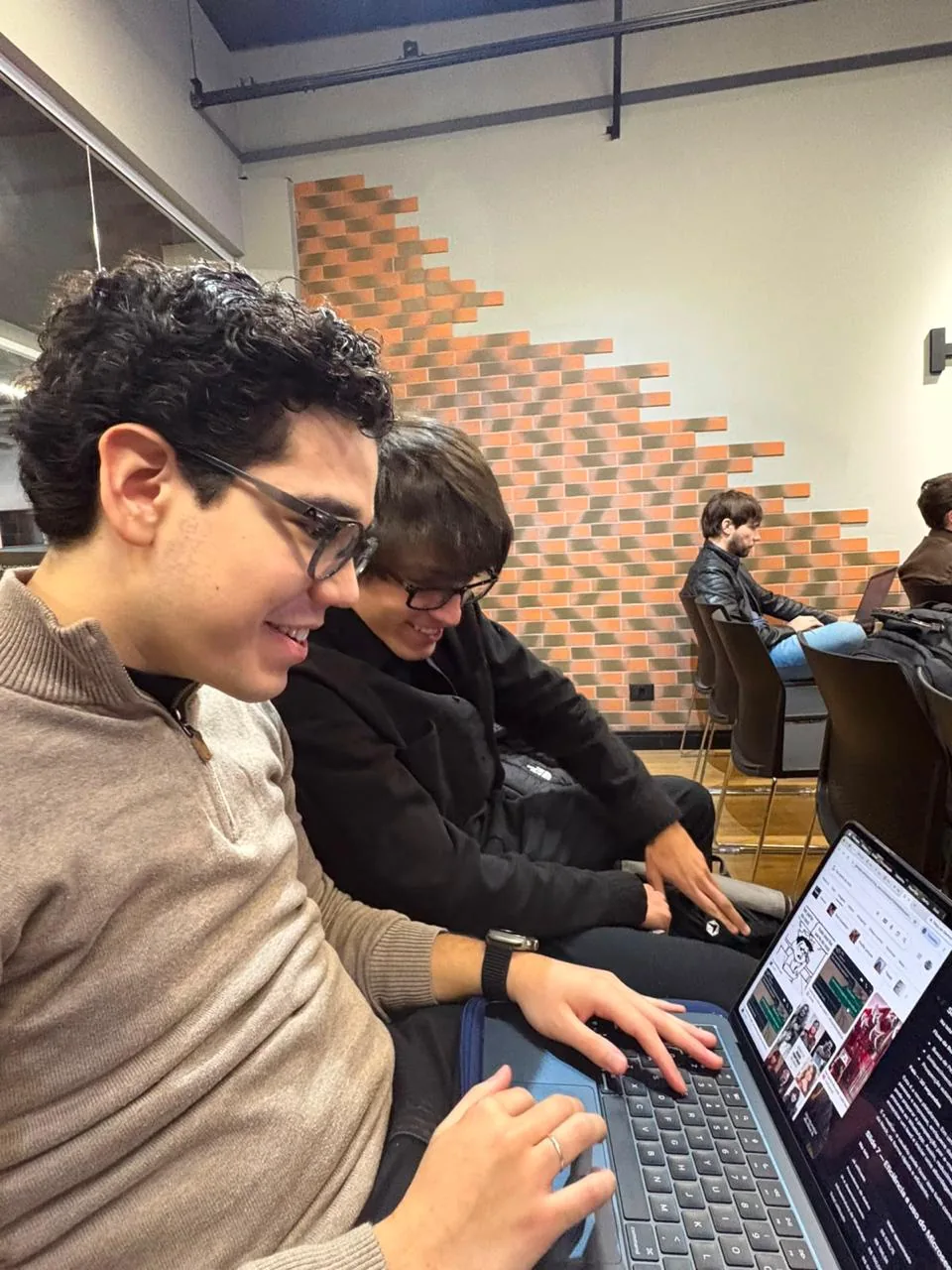 Two Nock team members working together on a laptop during an event.